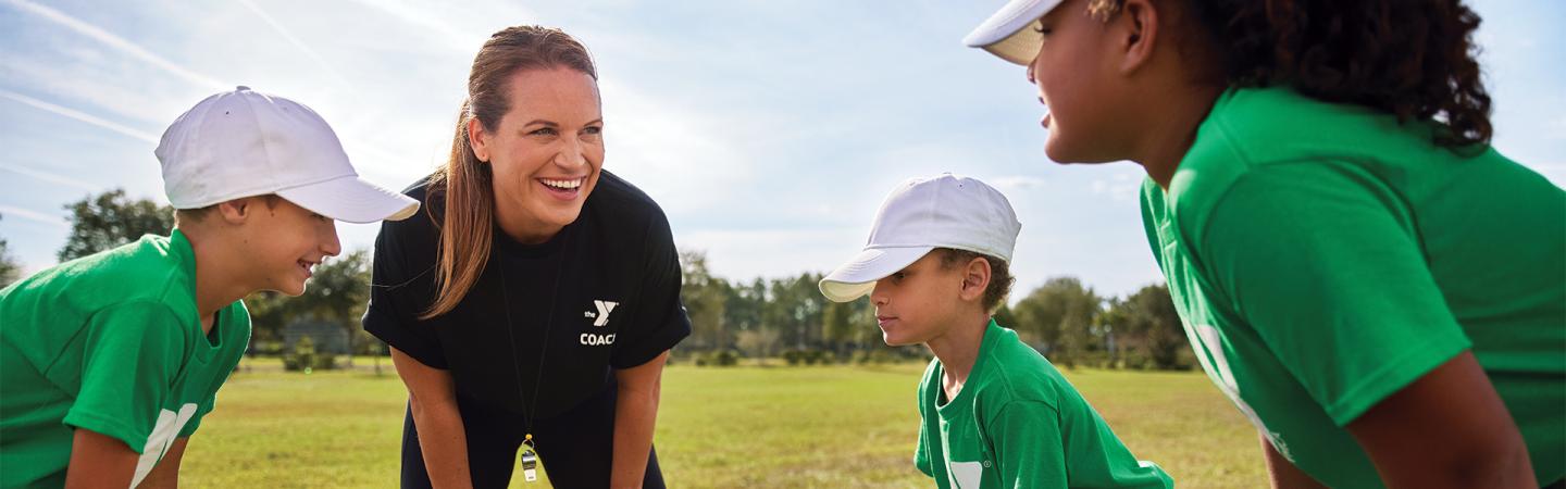 Coach teaching baseball to kids at the Y